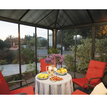 Coin salon couvert avec table, fleurs et mobilier rouge