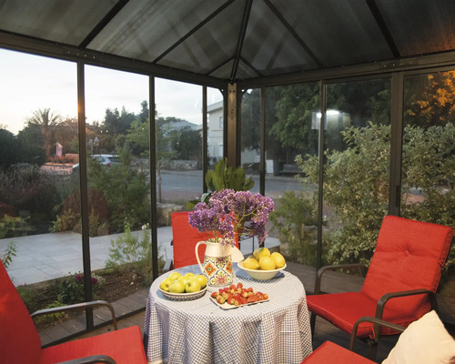 Coin salon couvert avec table, fleurs et mobilier rouge