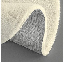 Vue détaillée d'un tapis rond avec une surface à poils et un envers en tissu