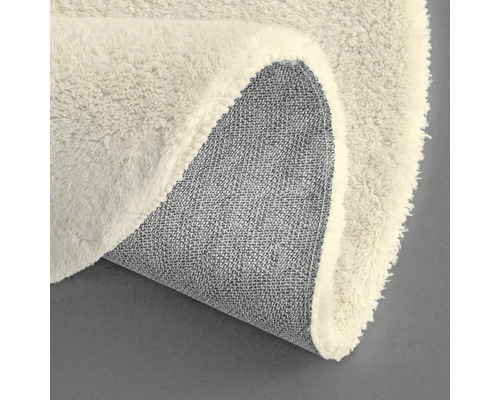 Vue détaillée d'un tapis rond avec une surface à poils et un envers en tissu