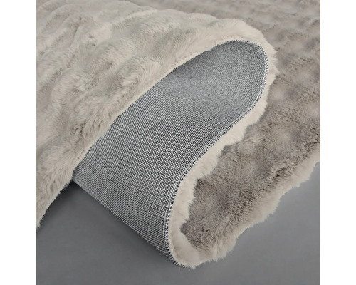 Vue détaillée d'un tapis à l'aspect fourrure avec un dos tissé