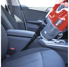 Aspirateur à main en cours d'utilisation pour nettoyer l'intérieur d'une voiture