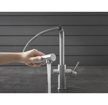 Robinet de cuisine avec douchette extractible et jet d'eau dans la main
