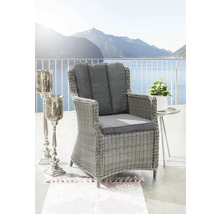 Fauteuil de jardin avec coussins gris, table d'appoint et bougeoir sur une terrasse avec vue sur le lac