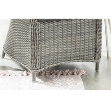 Gros plan d'une chaise de jardin en rotin sur un tapis à motifs