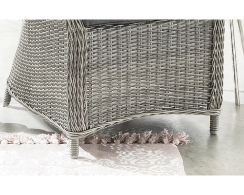 Gros plan d'une chaise de jardin en rotin sur un tapis à motifs