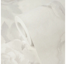 Rouleau de papier peint avec surface texturée et motif floral discret.