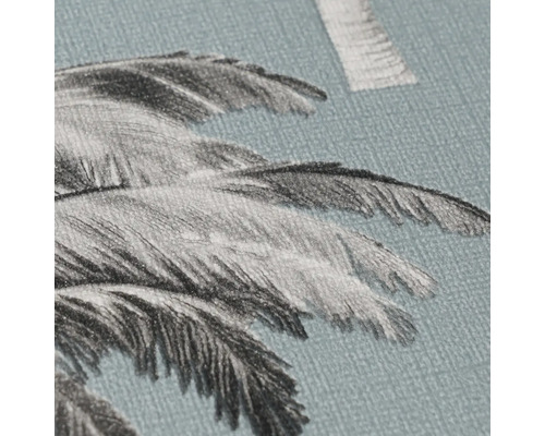 Détail d'un papier peint bleu avec motif de feuilles de palmier et surface structurée.