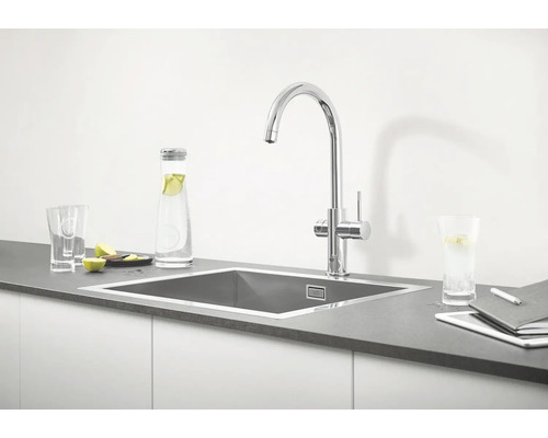 Évier de cuisine avec robinet, bouteille d'eau, verres et tablette