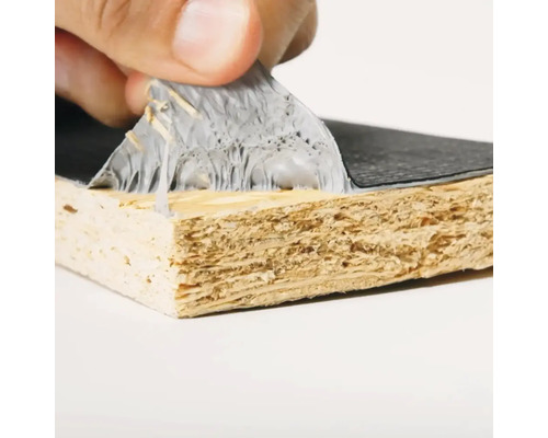 Nahaufnahme einer Hand, die eine Schutzfolie von einer beschichteten Holzplatte abzieht