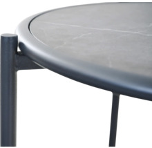 Vue détaillée d'une table d'appoint ronde avec un plateau aspect pierre et un cadre en métal foncé.
