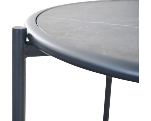 Vue détaillée d'une table d'appoint ronde avec un plateau aspect pierre et un cadre en métal foncé.