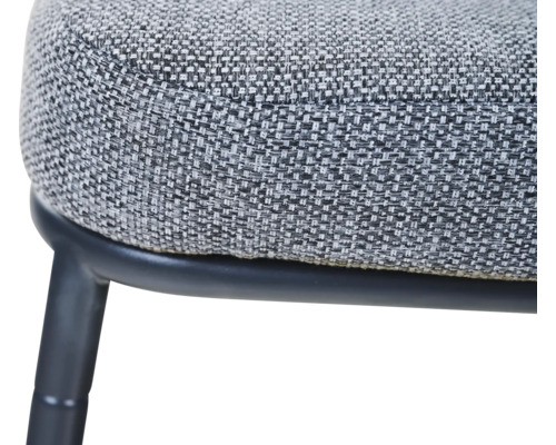 Gros plan d'une assise en tissu tissé avec un piétement en métal noir.