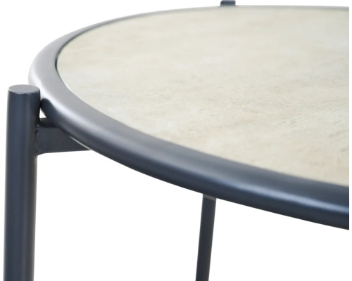 Gros plan sur une table de jardin ronde avec cadre métallique et plateau aspect pierre.