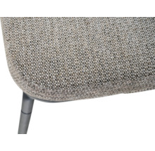 Détail d'une chaise avec revêtement en tissu texturé et un pied en métal sombre.