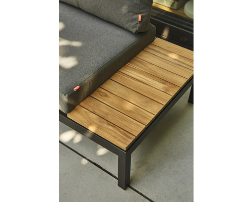 Salon de jardin avec cadre en métal noir, coussins gris et tablette intégrée en lattes de bois.