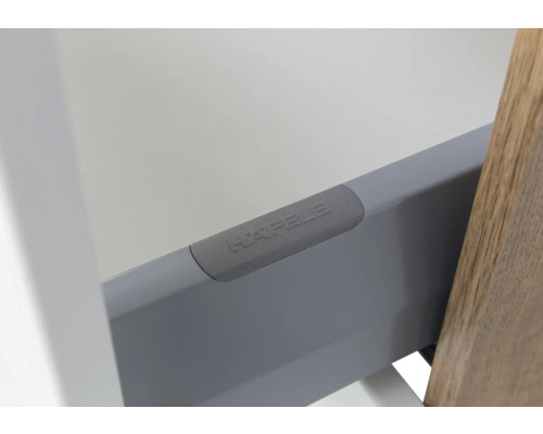 Detailansicht einer grauen Schubladenzarge aus Metall mit Häfele Logo.