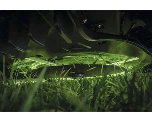 Gros plan d'une tondeuse à gazon coupant de l'herbe