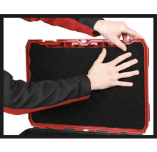 Personne insérant un insert en mousse dans une boîte à outils.