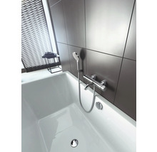 Salle de bains avec baignoire blanche et robinetterie avec douchette devant un mur gris