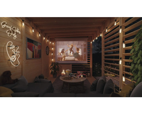 Espace extérieur confortable avec écran de projection, guirlandes lumineuses et sièges pour une soirée cinéma détendue