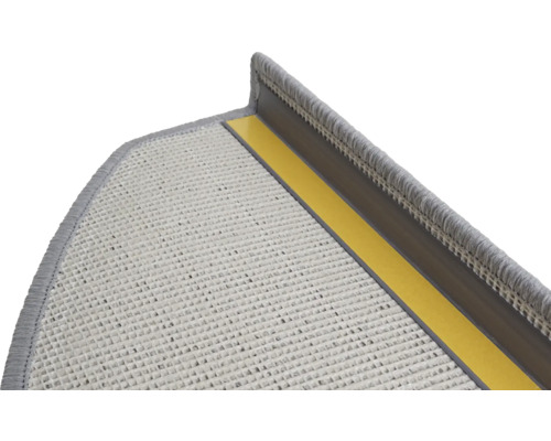 Gros plan d'une marche d'escalier avec tapis de protection et bandes de fixation