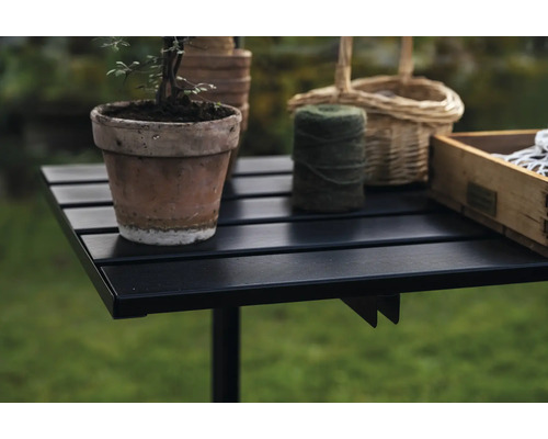 Table de jardin avec pot de fleurs, bobine de fil et caisse en bois