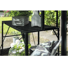Étagère à plantes noire avec plantes et décoration dans le jardin