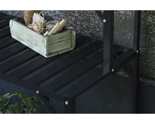 Vue détaillée d'une étagère à plantes noire avec une caisse en bois décorée