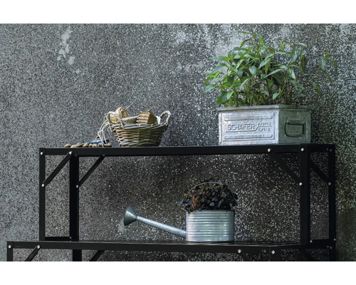 Étagère métallique noire avec des outils de jardin tels qu'un arrosoir, des plantes et un panier
