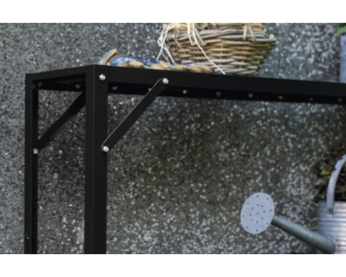 Vue détaillée d'une table de jardin noire avec décoration et arrosoir