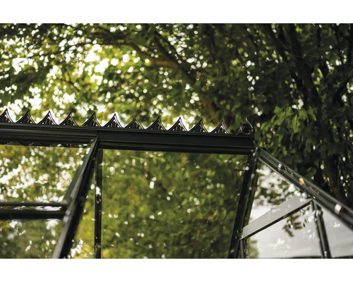 Detailansicht eines Gewächshauses mit Glasfenstern und dekorativer Dachspitze