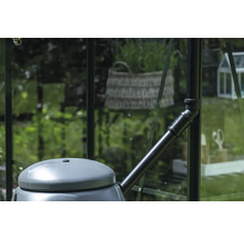 Récupérateur d'eau de pluie avec raccord de tuyau de descente dans une serre.