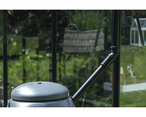 Récupérateur d'eau de pluie avec raccord de tuyau de descente dans une serre.