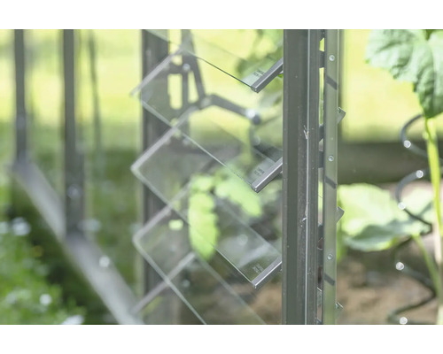 Vue détaillée d'une serre avec fenêtre à lamelles en verre pour la ventilation.