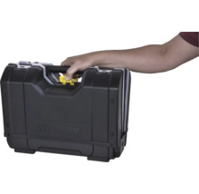 Main portant une caisse à outils Stanley par la poignée et appuyant sur le bouton de déverrouillage jaune.