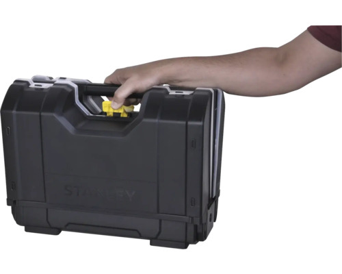 Main portant une caisse à outils Stanley par la poignée et appuyant sur le bouton de déverrouillage jaune.