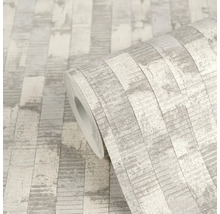 Papier peint intissé avec motif à rayures verticales aspect pierre ou bois, gris clair structuré.