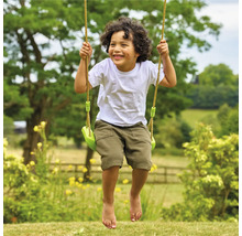 Garçon souriant sur balançoire de jardin