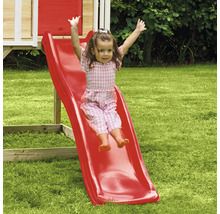 Fille glissant sur un toboggan rouge pour enfants dans le jardin
