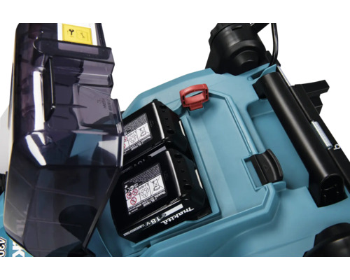 Compartiment batterie d'une tondeuse à gazon sans fil Makita avec deux batteries Lithium-Ion 18 Volts et clé de sécurité.
