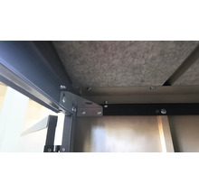 Detailansicht der Unterseite eines Tisches mit Schrauben und Metallverstärkungen.