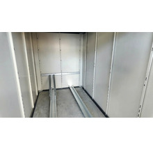 Vue intérieure d'une armoire de stockage avec des éléments métalliques pour le montage des étagères.