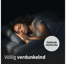 Frau schläft in vollständig abgedunkeltem Raum