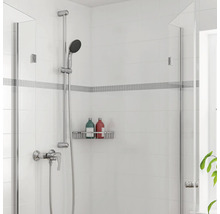 Modernes Duschset mit Handbrause, Mischbatterie und wandmontiertem Duschkorb auf weißen Fliesen mit Mosaikbordüre.