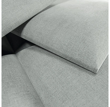 Gros plan d'un tissu d'ameublement gris à texture tissée avec des éléments de tissu qui se chevauchent.