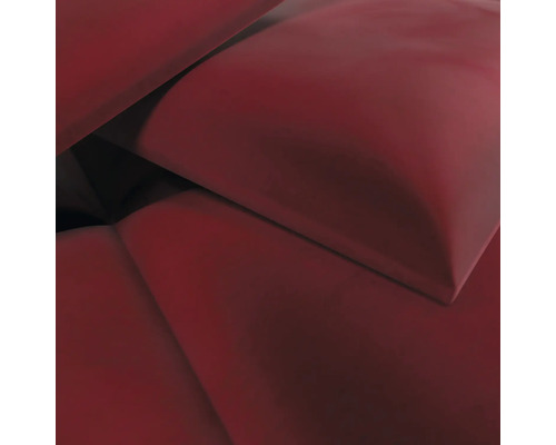 Nahaufnahme eines weichen, dunkelroten Dekokissens.