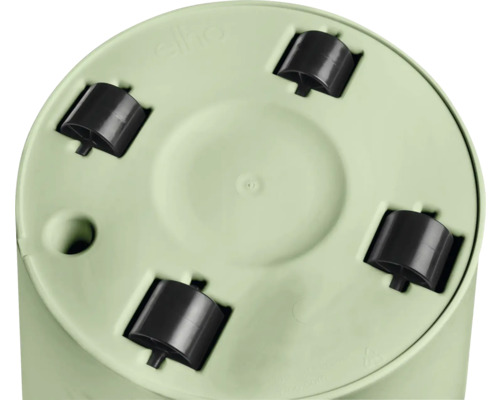 Vue de dessous d'un pot de fleurs rond vert clair avec quatre roulettes en plastique noir et trou de drainage.
