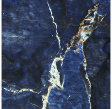 Nahaufnahme einer Fliese in blauer Marmoroptik mit weissen und goldfarbenen Adern.