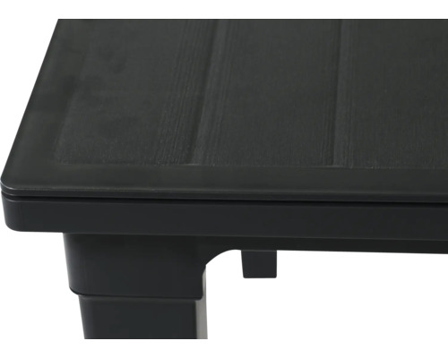 Vue détaillée du coin d'une table de jardin en plastique avec structure en bois.